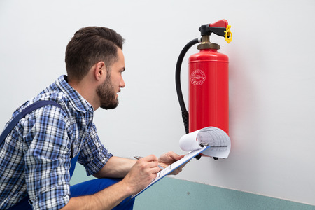 Man checking fire extinguisher